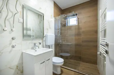 a bathroom with a toilet and a sink and a shower at V & V Studio Apartments 2 in Niš
