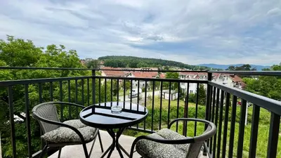 a balcony with two chairs and a table on a balcony at Apartman Gorsky in Vrnjačka Banja