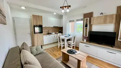 a living room with a couch and a tv and a kitchen at Apartman Gorsky in Vrnjačka Banja