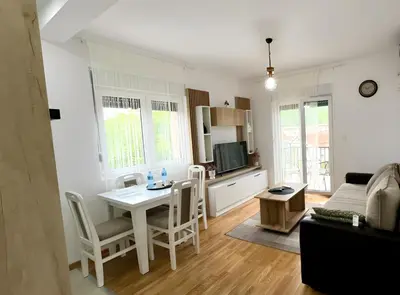 a kitchen and living room with a table and chairs at Apartman Gorsky in Vrnjačka Banja