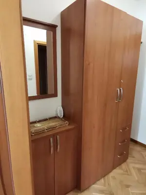 a bathroom with a mirror and a wooden cabinet at B&P apartman Vrnjačka Banja in Vrnjačka Banja