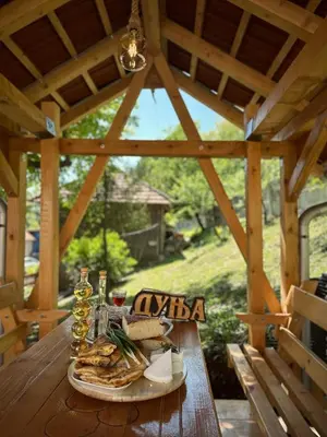a wooden table with a plate of food on it at Seosko turističko domaćinstvo DUNJA in Osnić