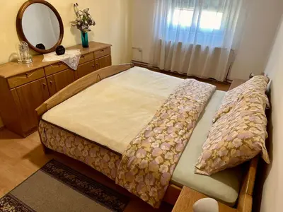 a bedroom with a bed with a mirror and a dresser at Seosko turističko domaćinstvo DUNJA in Osnić