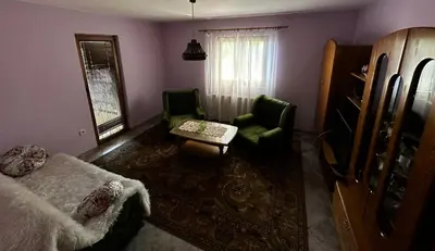 a living room with a couch and a chair and a table at Seosko turističko domaćinstvo DUNJA in Osnić
