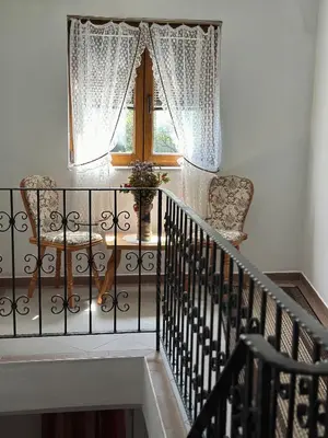 a staircase with two chairs and a window at Seosko turističko domaćinstvo DUNJA in Osnić