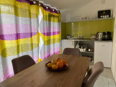 a kitchen with a table with a bowl of fruit on it at Apartments and Rooms Radivojević Niš in Niš