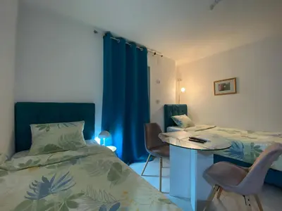 a bedroom with a bed and a table and chairs at Apartments and Rooms Radivojević Niš in Niš