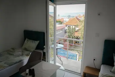 a room with a bed and a balcony with a view at Apartments and Rooms Radivojević Niš in Niš