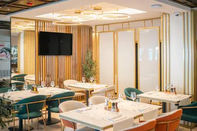 a restaurant with tables and chairs and a flat screen tv at Hotel Kocka Vrnjačka Banja in Vrnjačka Banja
