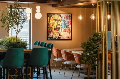 a restaurant with a table and chairs and a painting at Hotel Kocka Vrnjačka Banja in Vrnjačka Banja