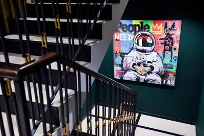 a staircase with a poster of an astronaut on the wall at Hotel Kocka Vrnjačka Banja in Vrnjačka Banja