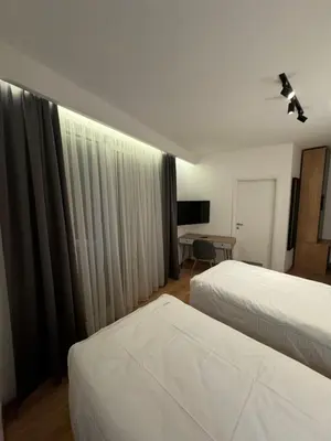 a hotel room with two beds and a television at Triangle Rooms in Raška