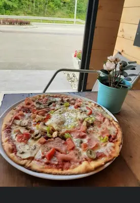 a pizza sitting on top of a table at Triangle Rooms in Raška