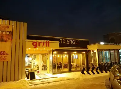 a shopping center with a car parked in front of it at Triangle Rooms in Raška