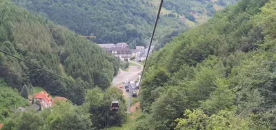 a gondola ride up a mountain with a town on a road at Apartman Snezni Vrh - Bela Reka, Brzece in Brzeće
