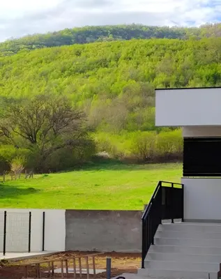 a building with stairs and a green field at OPERA LUX APARTMENTS Green Hill - Relax & Free Parking in Soko Banja