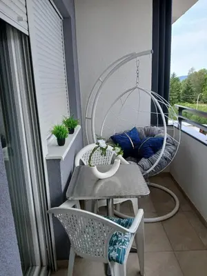 a balcony with a table and chairs on a balcony at OPERA LUX APARTMENTS Green Hill - Relax & Free Parking in Soko Banja