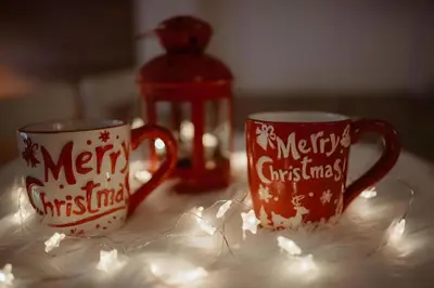 two christmas mugs sitting on a table with lights at OPERA LUX APARTMENTS Green Hill - Relax & Free Parking in Soko Banja
