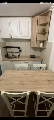 a kitchen with a wooden table and white cabinets at Bela Reka Gondola Studio in Brzeće