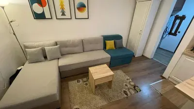 a living room with a couch and a table at Bela Reka Gondola Studio in Brzeće