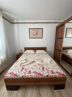 a bedroom with a bed with a floral bedspread at Apartmani Dora Leskovac in Leskovac