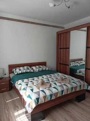 a bedroom with a bed and a large mirror at Apartmani Dora Leskovac in Leskovac