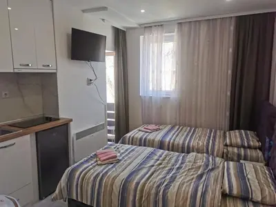 a hotel room with two beds and a kitchen at Apartman Aleksandar 2 in Ribarska Banja