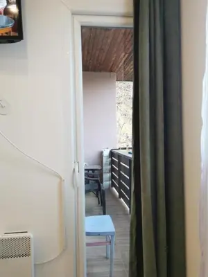 a door to a room with a table and a chair at Apartman Aleksandar 2 in Ribarska Banja