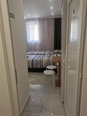 a bedroom with a bed and a table and a stool at Apartman Aleksandar 2 in Ribarska Banja