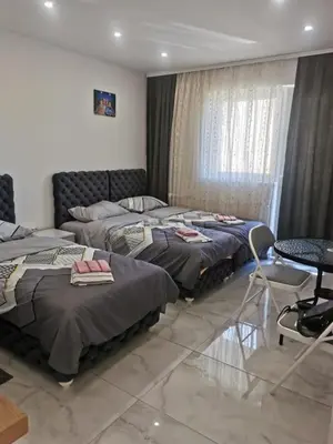 a bedroom with two beds and a table and chairs at Apartman Aleksandar 1 in Ribarska Banja