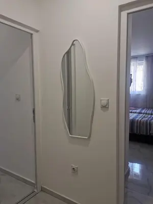 a mirror hanging on a wall next to a door at Apartman Aleksandar 1 in Ribarska Banja