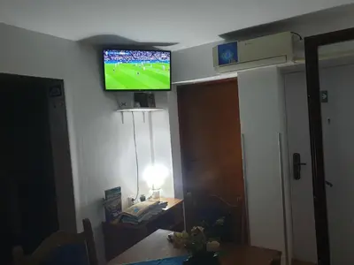 a living room with a television on the wall at Apartman Kotin in Pirot