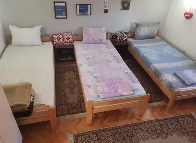 a room with two beds and a table at Apartman Kotin in Pirot