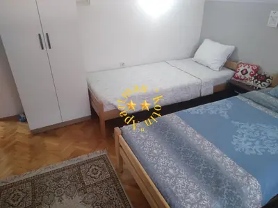 a small room with two beds and a table at Apartman Kotin in Pirot