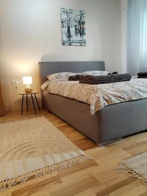 a bedroom with a bed and a table with a lamp at Studio Iris 1 in Niš