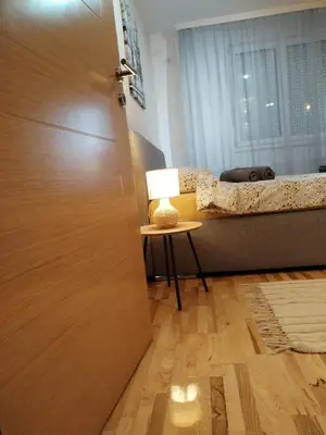 a door leading to a bedroom with a bed and a table at Studio Iris 1 in Niš