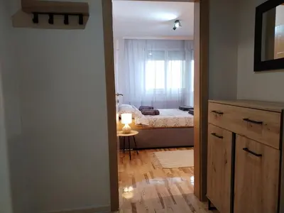 a room with a bedroom with a bed and a window at Studio Iris 1 in Niš