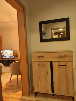 a room with a wooden dresser and a mirror at Studio Iris 1 in Niš