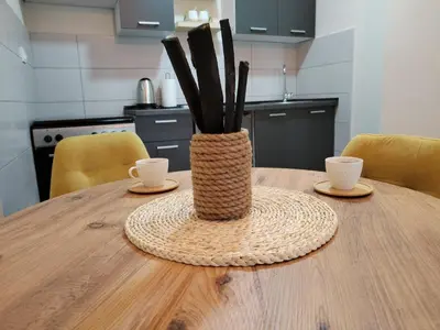 a vase sitting on top of a wooden table with two cups at Studio Iris 1 in Niš