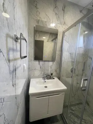 a white bathroom with a sink and a shower at Jutarnja Zvezda Kop in Kopaonik