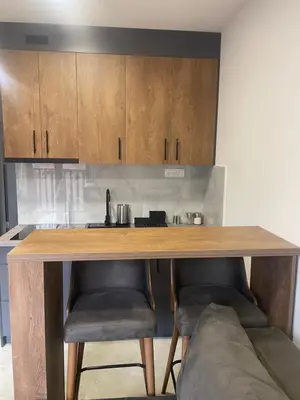 a kitchen with a wooden table with two bar stools at Jutarnja Zvezda Kop in Kopaonik