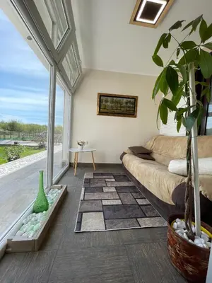 a living room with a couch and a large window at Diamona Lux Spa Apartman in Niš