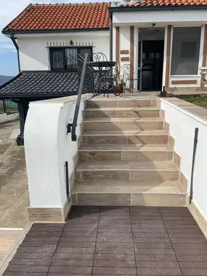 a staircase leading to a house with a table at Diamona Lux Spa Apartman in Niš