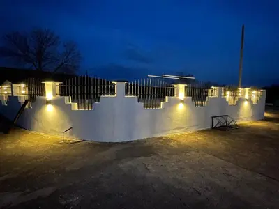 a white fence with lights on it at night at Diamona Lux Spa Apartman in Niš