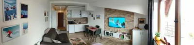 a living room with a couch and a kitchen with a counter at Apartman N Lux 100 Milmari resort in Kopaonik