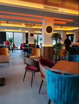 a restaurant with many tables and chairs and a unintention at Apartman N Lux 100 Milmari resort in Kopaonik