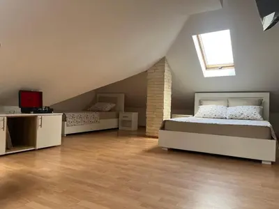 a attic bedroom with two beds and a window at Art Studio in Niš