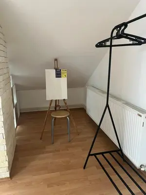 a stand up easel and a chair in a room at Art Studio in Niš