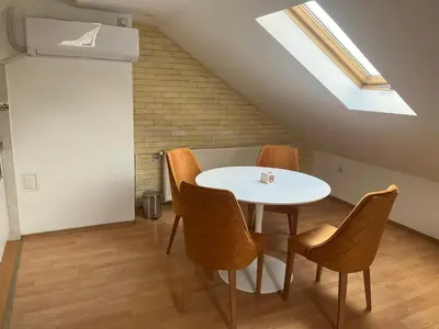 a dining room with a white table and chairs at Art Studio in Niš