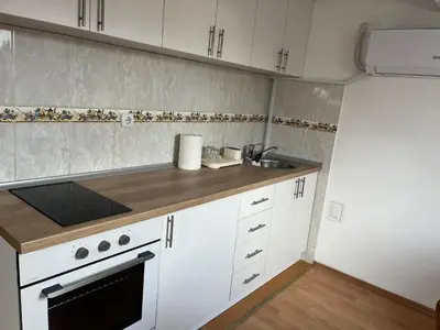 a kitchen with white cabinets and a sink at Art Studio in Niš